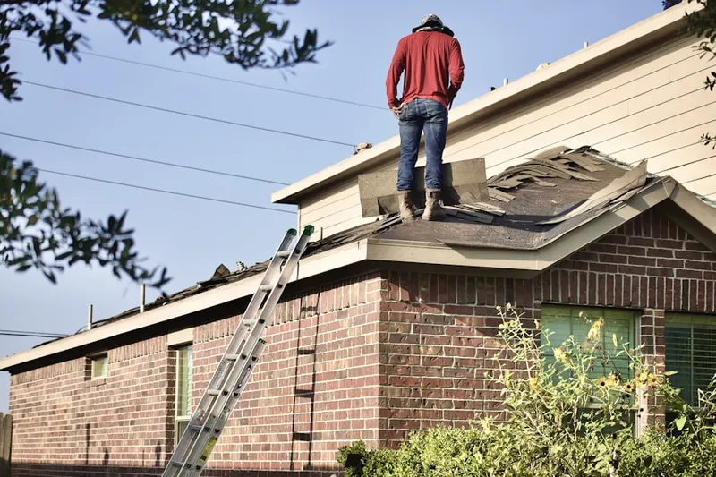 Professional roofer working on a residential roof in Bow